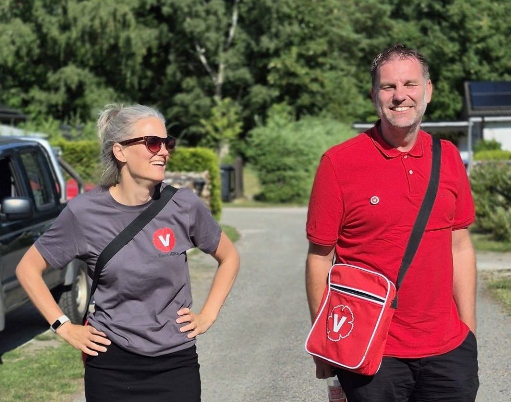 Två representanter för Vänsterpartiet Sjöbo står på en gata under dörrknackning i Sjöbo sommarby.